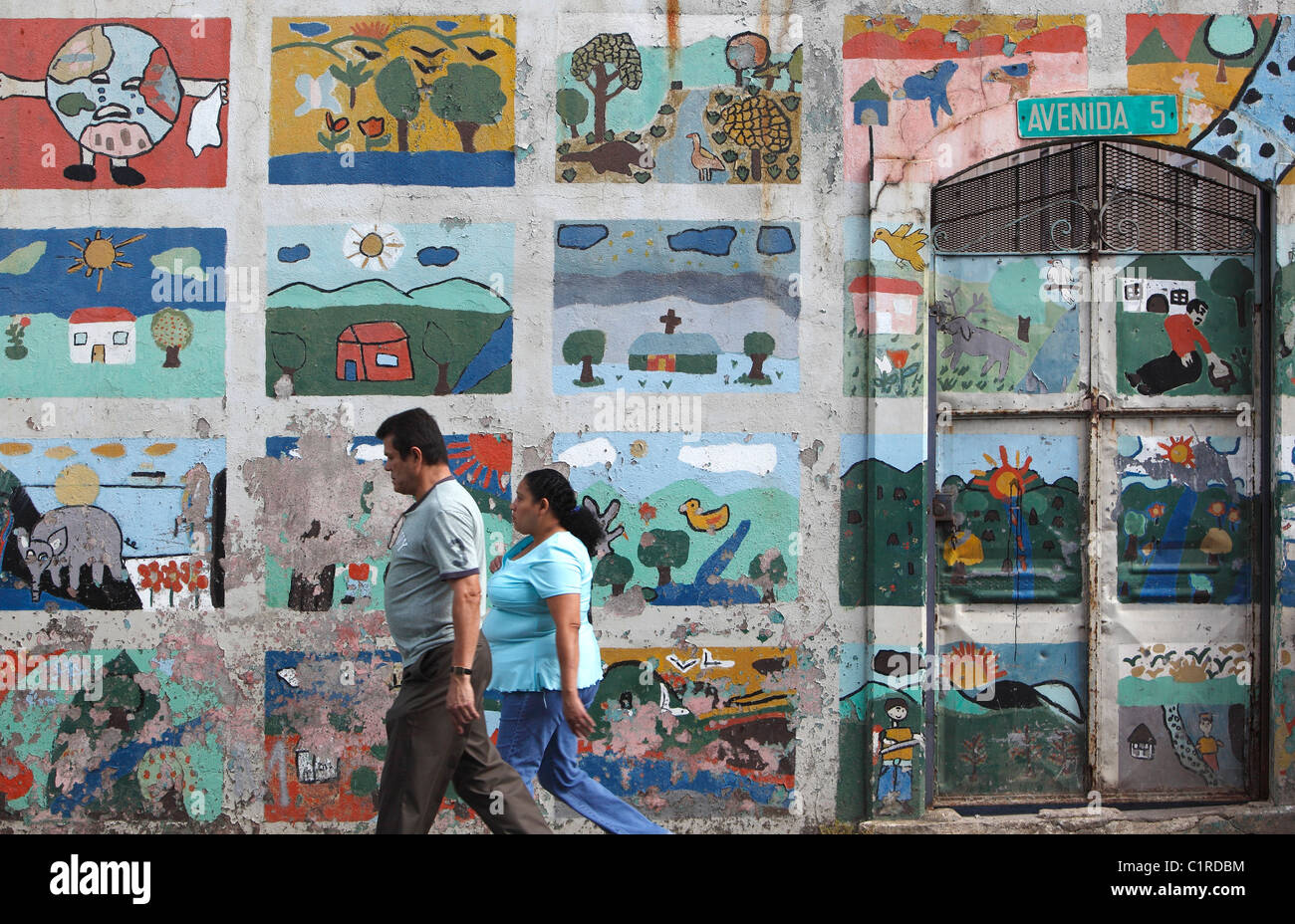 Ein Mann und eine Frau gehen vorbei an einem ökologischen Wandbild, San Jose, Costa Rica Stockfoto