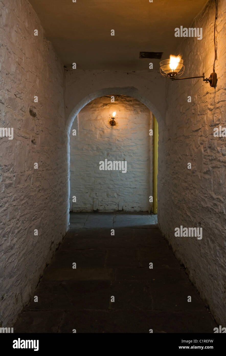 Blick von einer Gefängniszelle über einen gasbeleuchteten Gang im Keller des Judge's Lodging, Presteigne, Powys, einem preisgekrönten Museum des viktorianischen Lebens Stockfoto