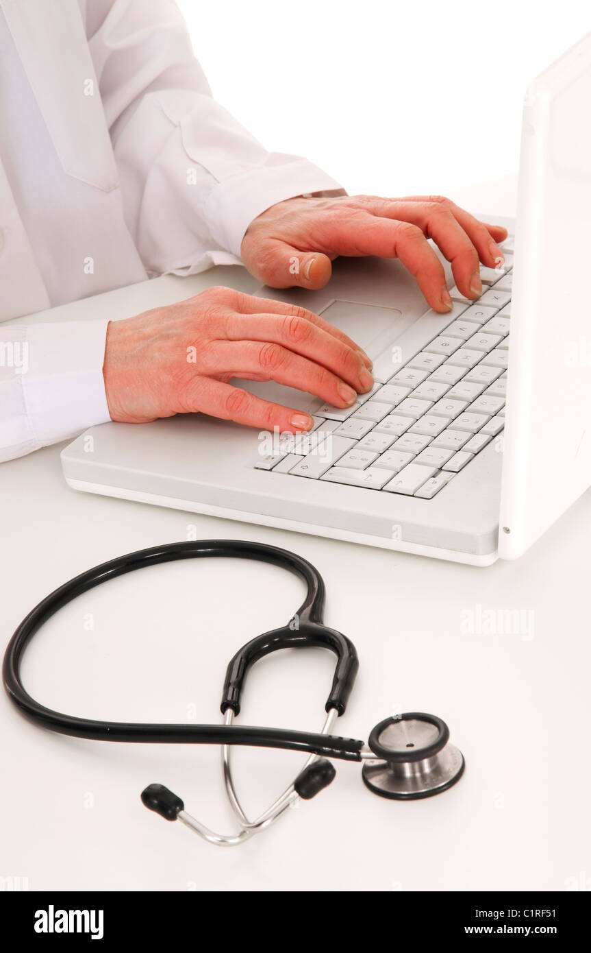 Arzt am Schreibtisch mit Stethoskop und laptop Stockfoto