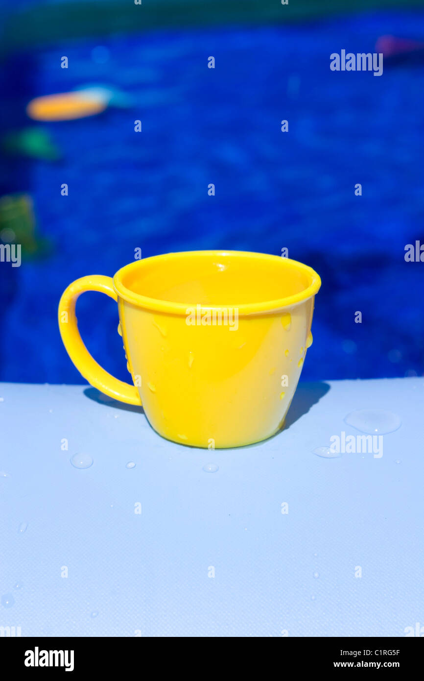 Gelber Kunststoff Teetasse auf blau Stockfoto