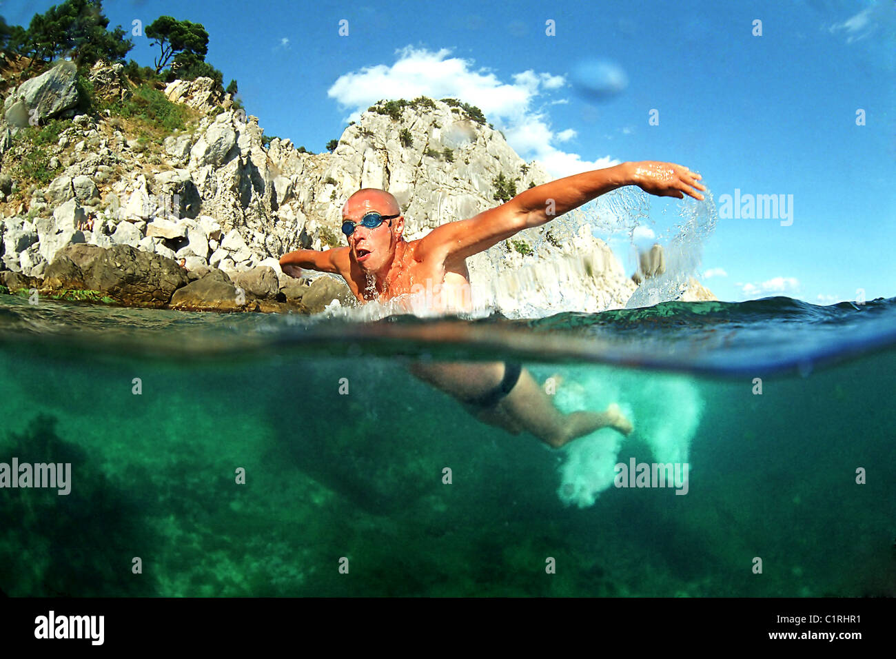 Split Level männliche Schwimmer schwimmt auf dem Meer Stockfoto