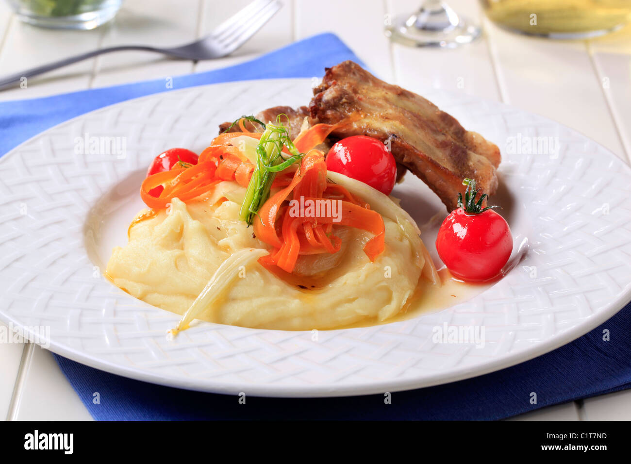 Gebratene Schweinerippchen und Kartoffel-Püree mit Gemüse garniert Stockfoto