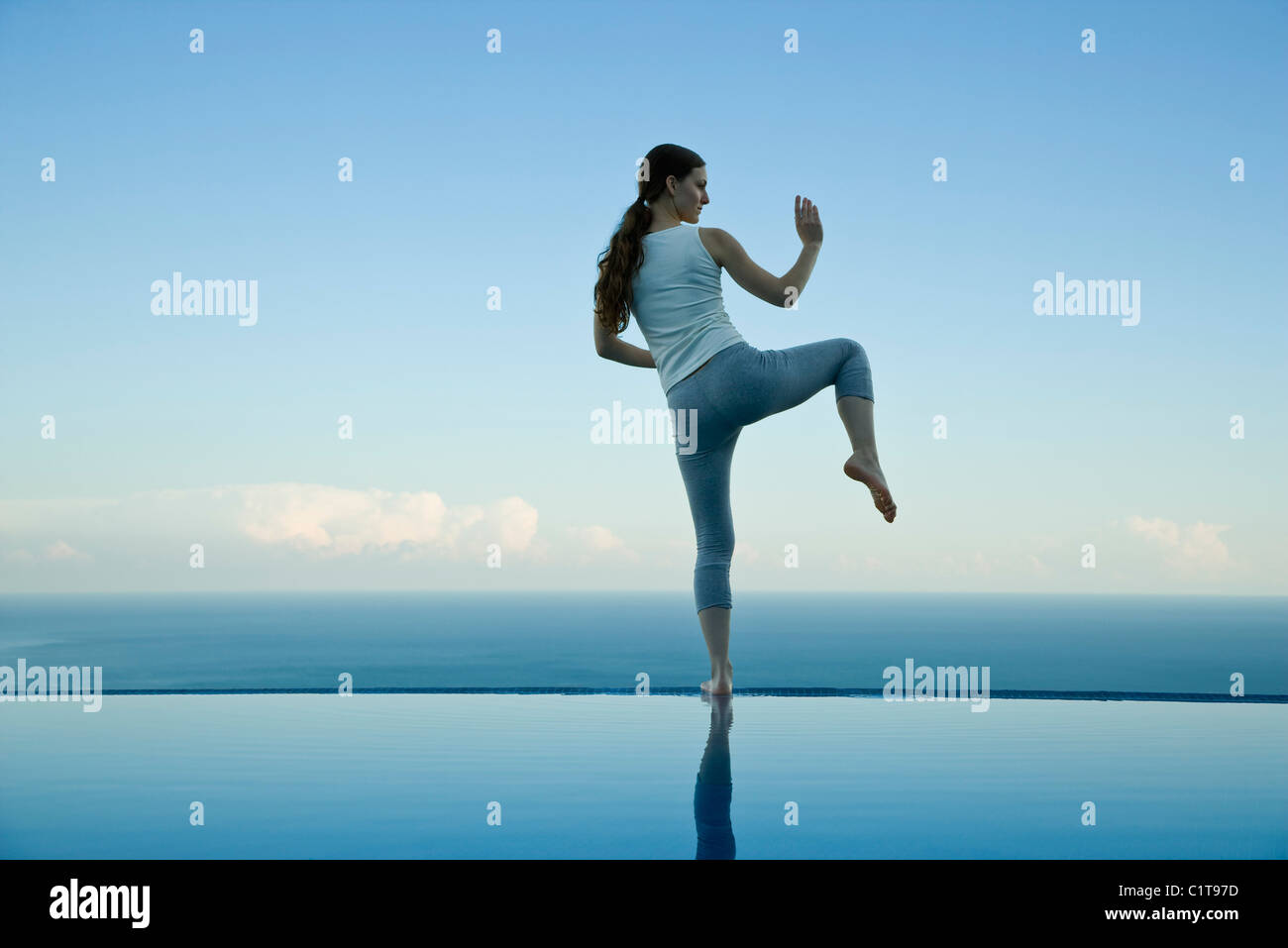Frau praktizieren Tai Chi Chuan am Rand des Infinity-pool Stockfoto
