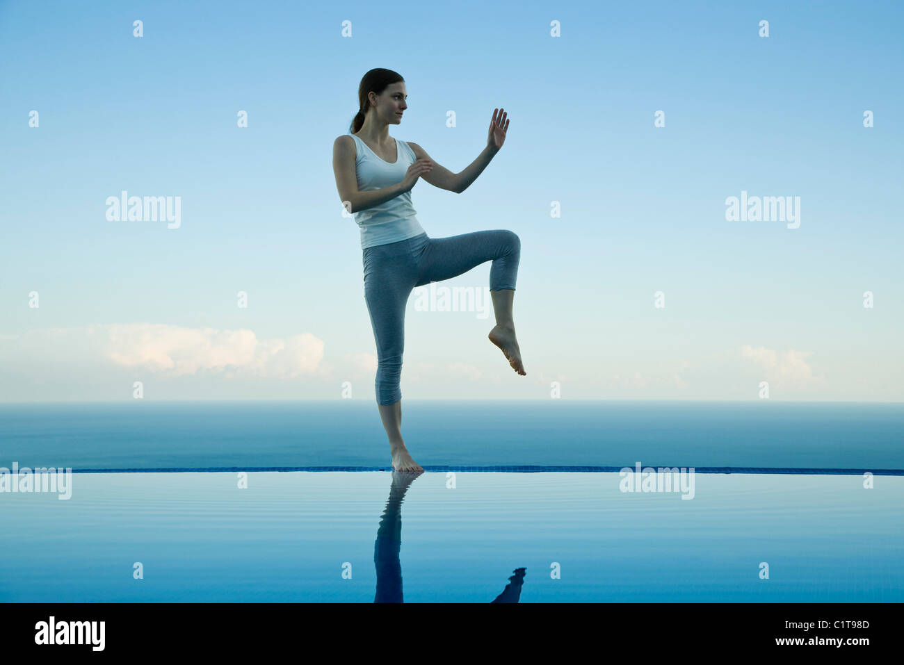 Frau praktizieren Tai Chi Chuan am Rand des Infinity-pool Stockfoto