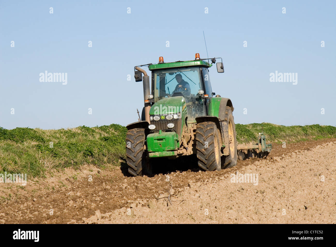 John Deere 7920 in einem Feld Norfolk UK arbeiten. Die Arbeit ist die Vorbereitung für das Bohren von Zuckerrüben. Stockfoto