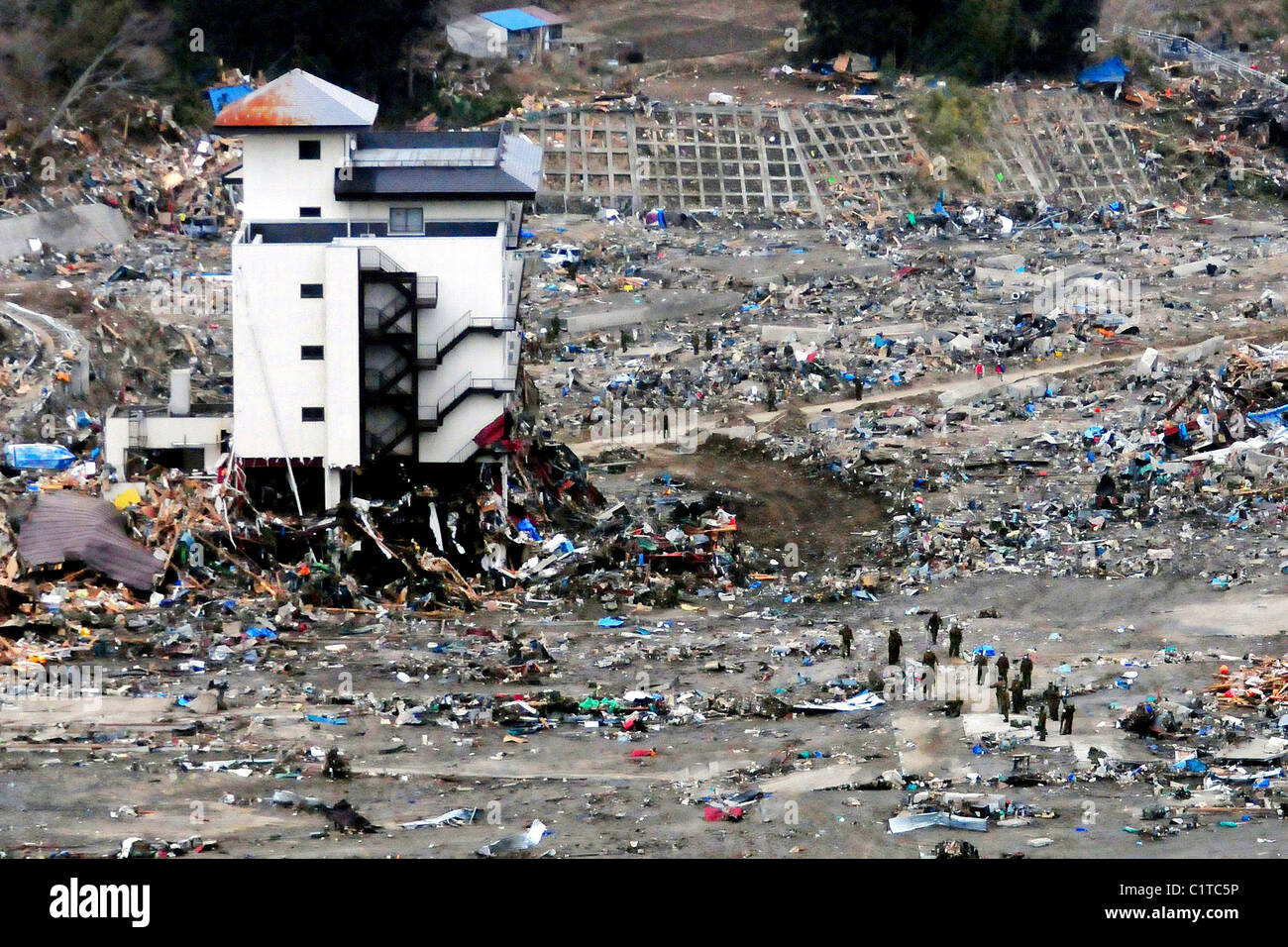 Ein japanisches Such- und Rettungsdienst-Team sucht den Schutt in der Nähe von einem Hochhaus in Wakuya, Japan nach einer 9.0 Größe earthquak Stockfoto
