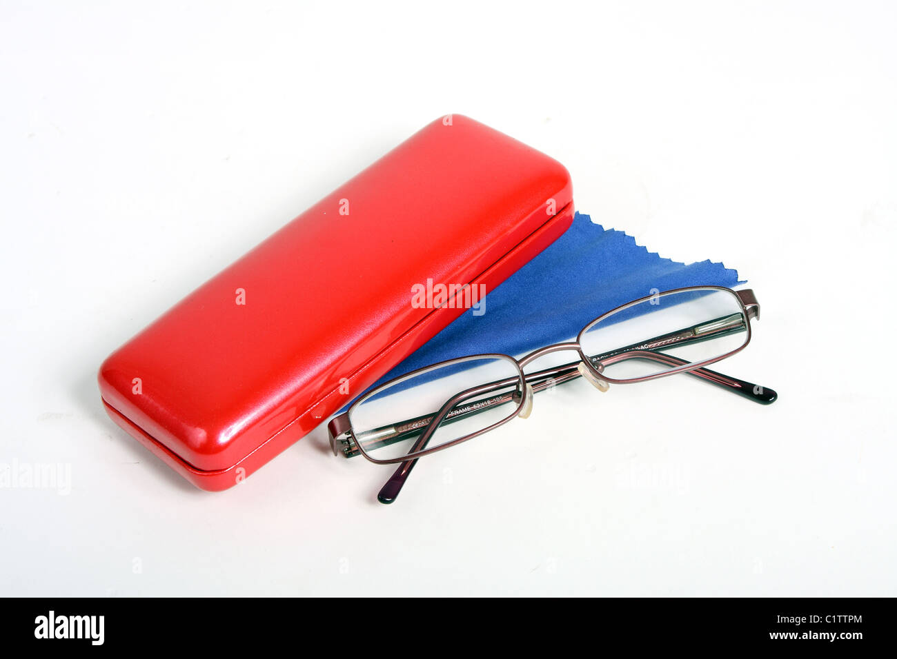 Ein paar von Burgund Lesebrille auf einem weißen ausgeschnitten Hintergrund mit einem roten Brillenetui und blau Reinigungstuch. Stockfoto