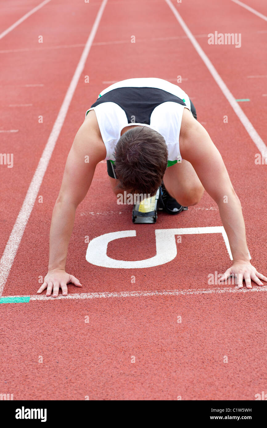 Sportlicher Mann warten im Startblock Stockfoto