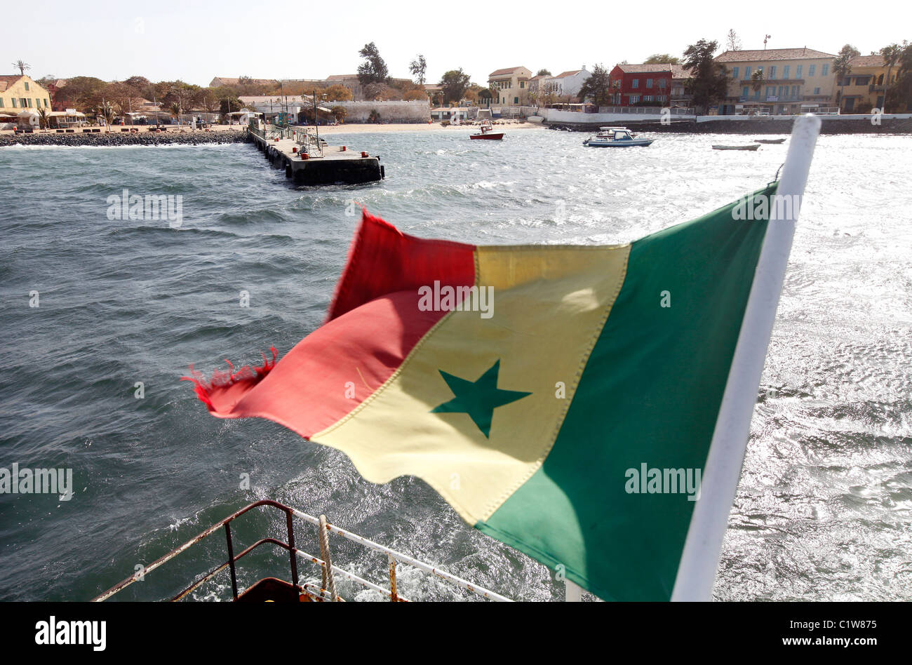 Senegalesische Flagge auf dem Boot zur Insel Gorée (im Hintergrund) Stockfoto