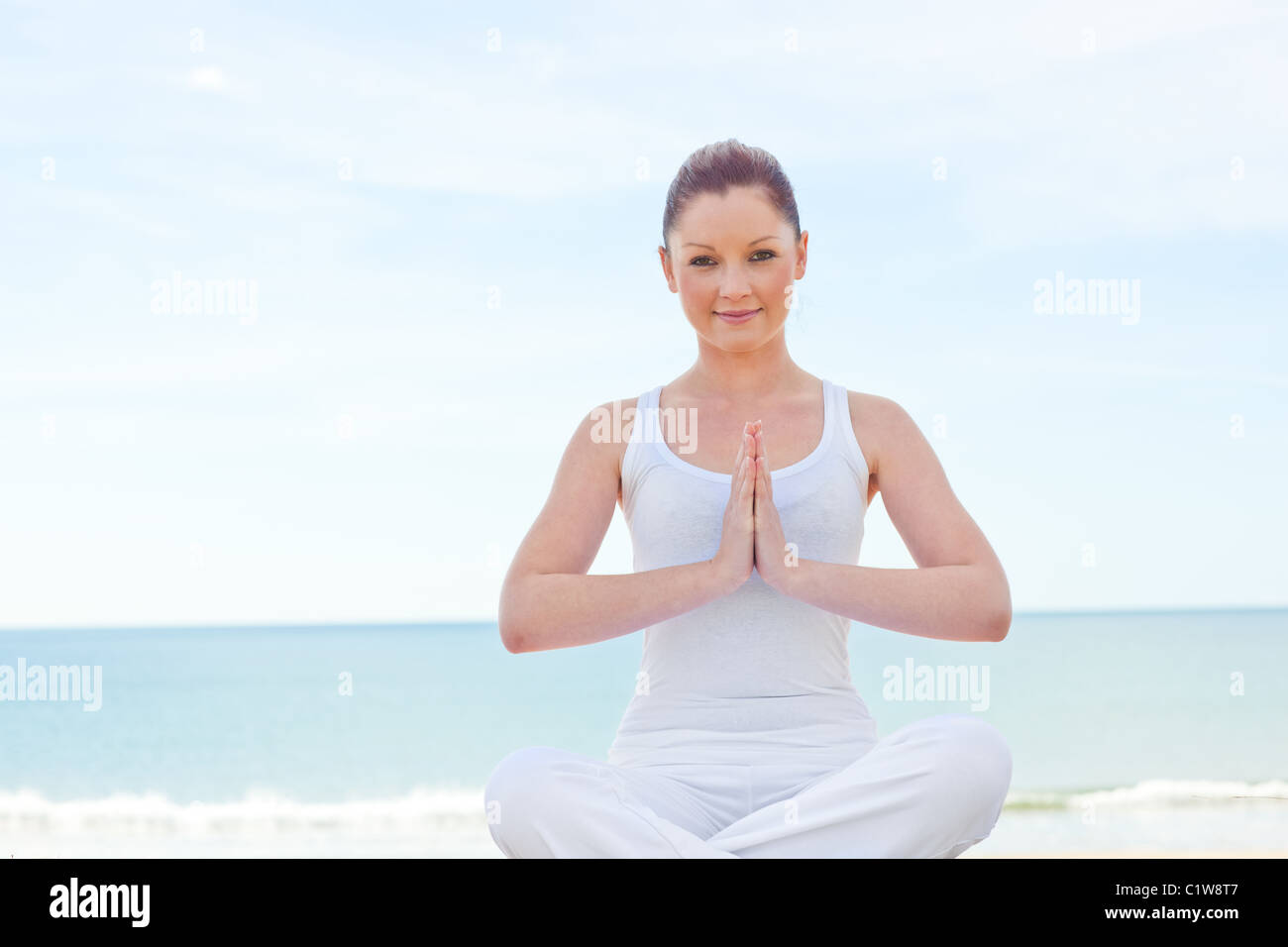 Frau praktizieren Yoga am Strand Stockfoto
