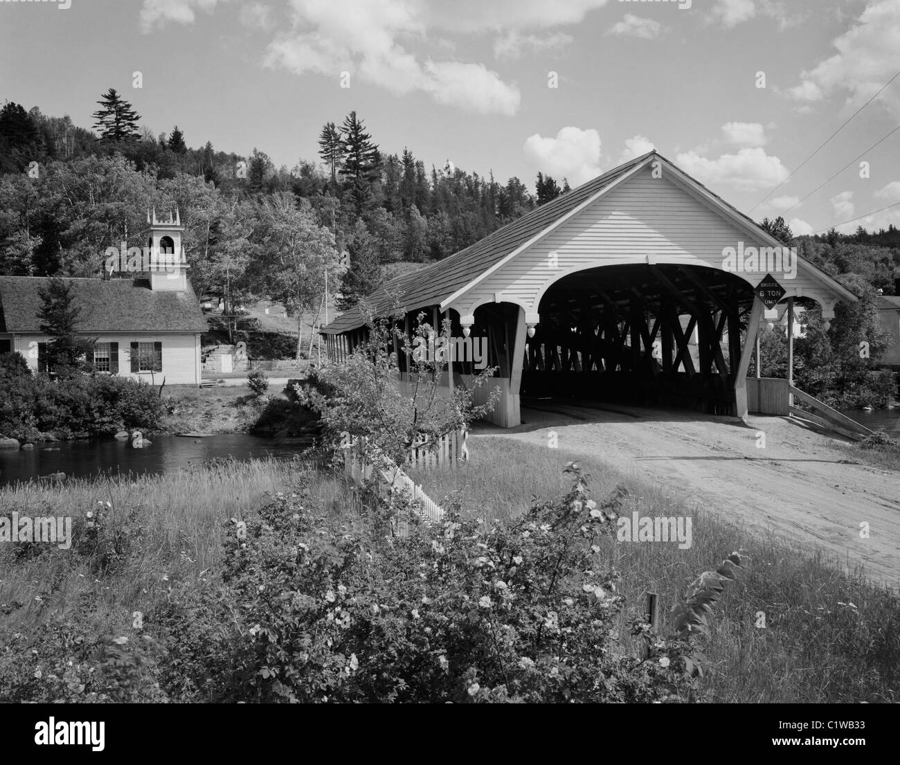 USA, New Hampshire, Stark, überdachte Brücke und Evangelisch-methodistische Kirche Stockfoto