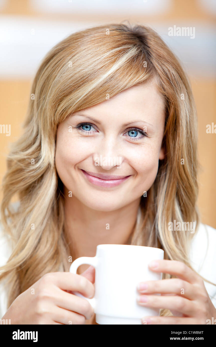 Lächelnde Geschäftsfrau hält eine Tasse Kaffee Stockfoto