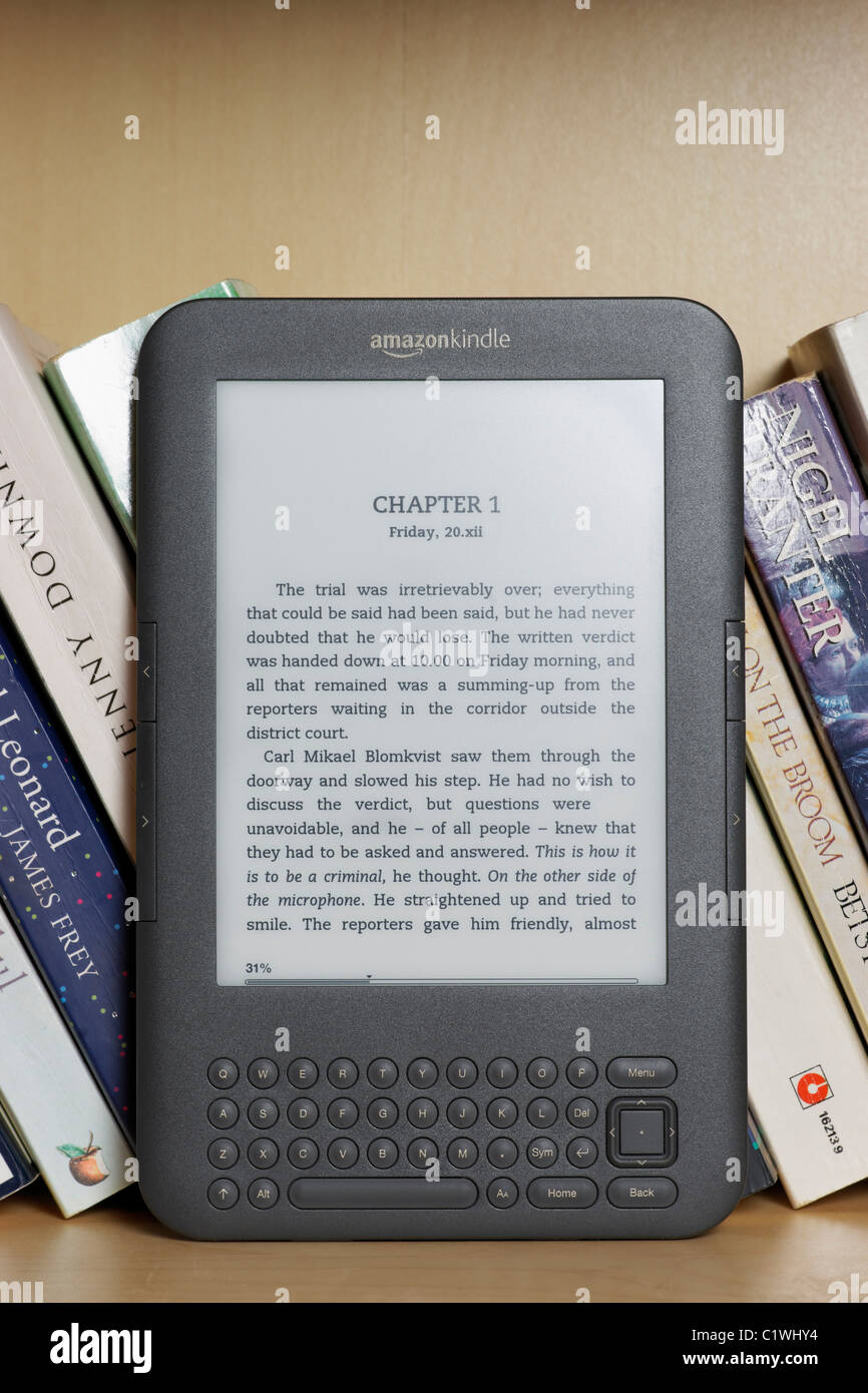 Ein Amazon Kindle Ebook Reader auf einem Bücherregal mit Taschenbüchern. Dies ist das Kindle 3-Modell.  NUR ZU REDAKTIONELLEN ZWECKEN Stockfoto