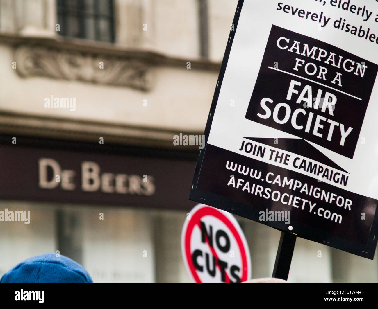 Ein Plakat protestieren für eine gerechtere Gesellschaft außerhalb von De Beers Juweliere in Piccadilly London am 26. März Stockfoto