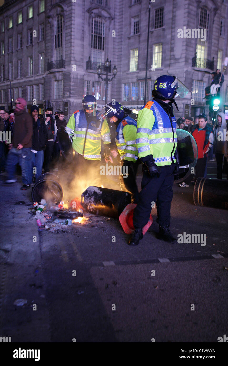 Bereitschaftspolizei löschte ein Feuer angezündet von Demonstranten in London Stockfoto