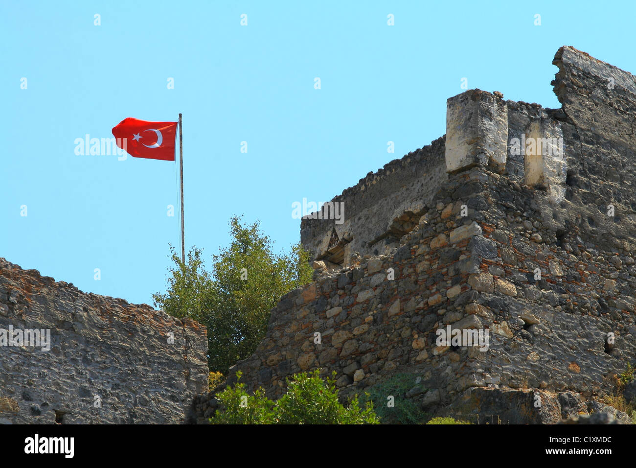 Türkische Flagge wächst über das Haus in verlassene Stadt Kayaköy. Fethiye, Türkei Stockfoto