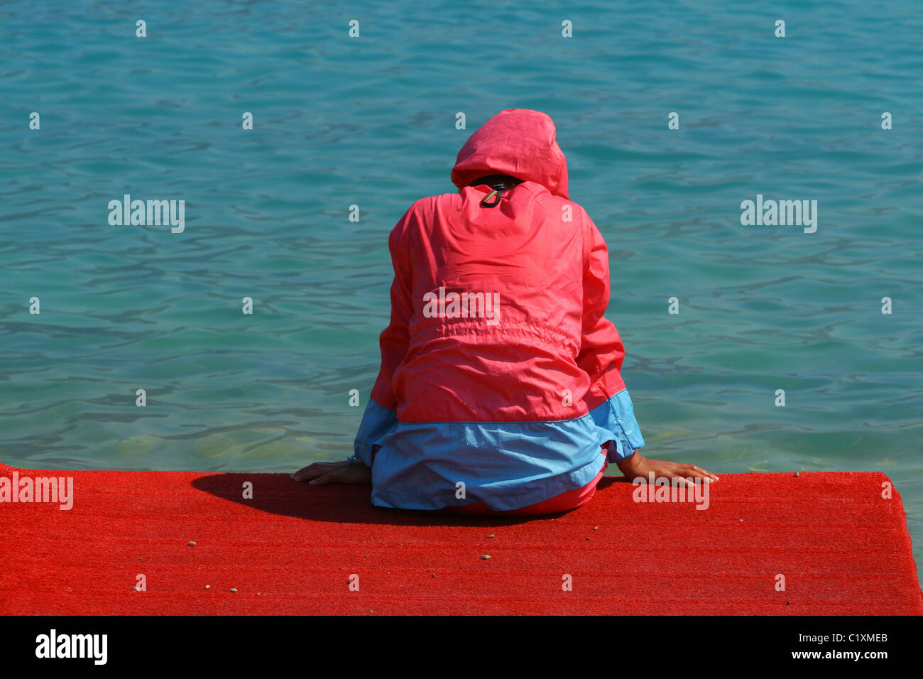 Frau sitzt wieder für uns auf der Anklagebank in muslimischen Badeanzug für Frauen (Burkini). Ölüdeniz, Ägäis, Mittelmeer, Türkei Stockfoto