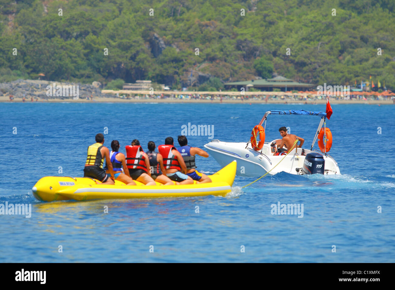 Sechs Leute sitzen auf einer Wasser-Banane vor ihrer Abschleppen von einem Boot. Sarigerme, Ägäis, Mittelmeer, Türkei Stockfoto
