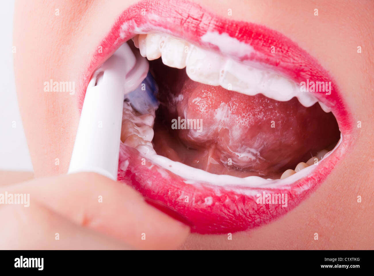 weiße Zähne sind mit einer elektrischen Zahnbürste geputzt. Stockfoto