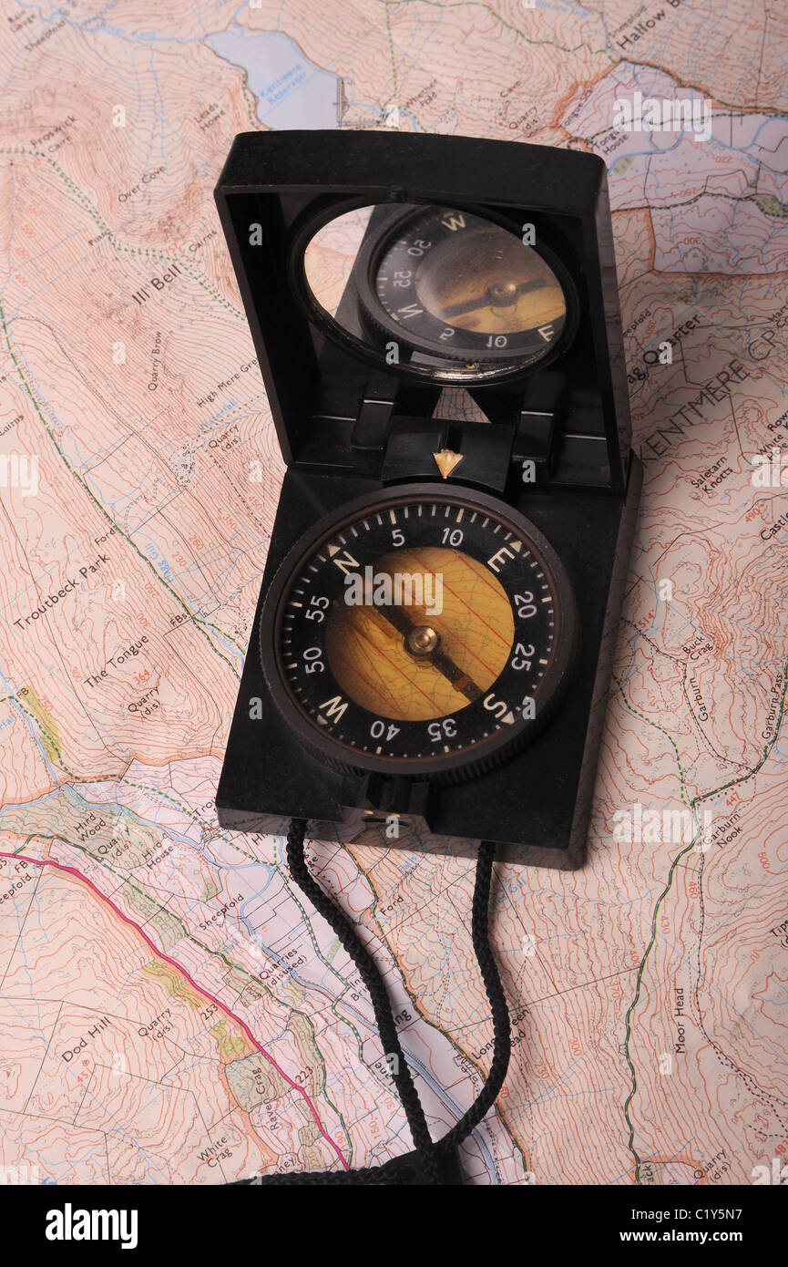 Ein prismatischer Kompass gelegt auf einer Karte in Fahrtrichtung zeigen Stockfoto