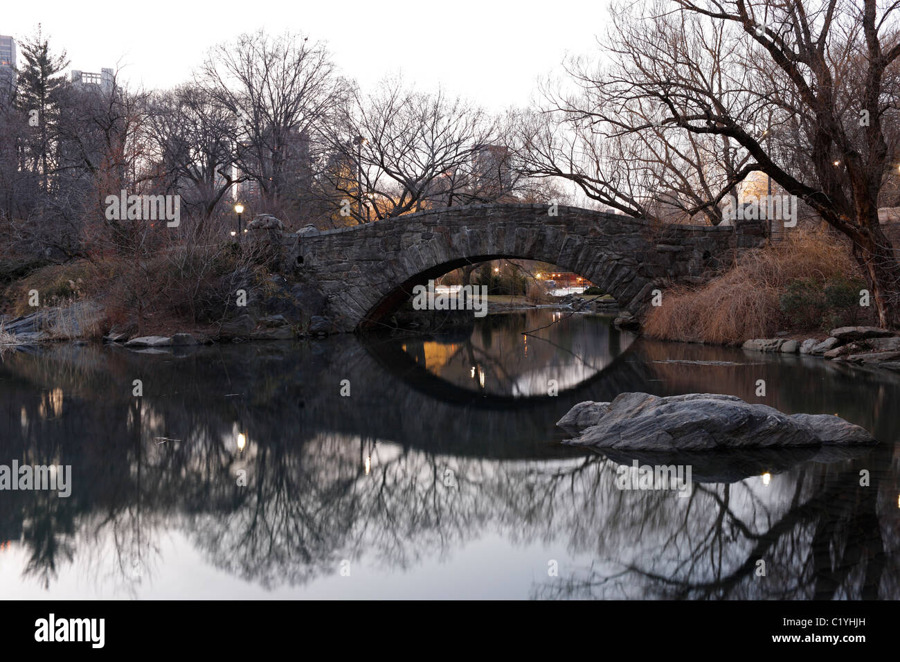 Gapstow Bridge im Winter aus dem Teich mit Spiegelungen im Wasser im New Yorker Central Park gesehen Stockfoto