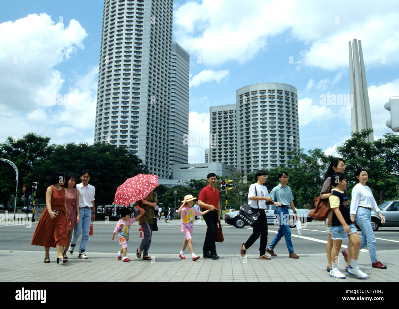 Singapur. Singapurische Familie Kreuz stark befahrenen Straße in der Nähe der Raffles Shopping Center in Downtown. © 2008 Stockfoto