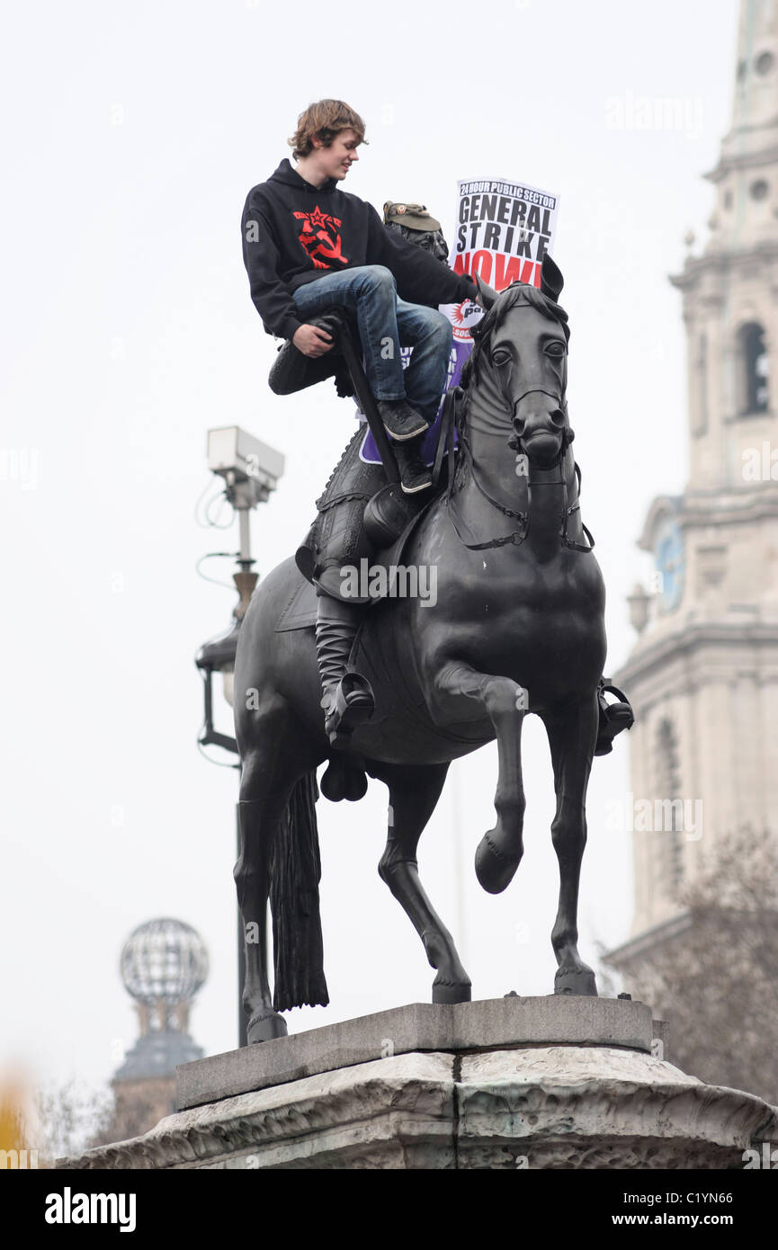 Demonstrant auf Statue in TUC Anti-Spending schneidet März, Trafalgar Square, London 26. März 2011 Stockfoto