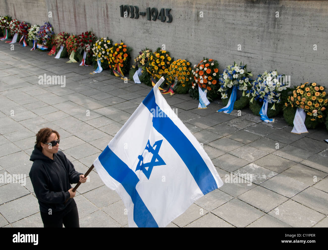Eine israelische Besucher mit Nationalflagge Israel besucht Gedenktag im KZ Dachau, Bayern, Deutschland Stockfoto