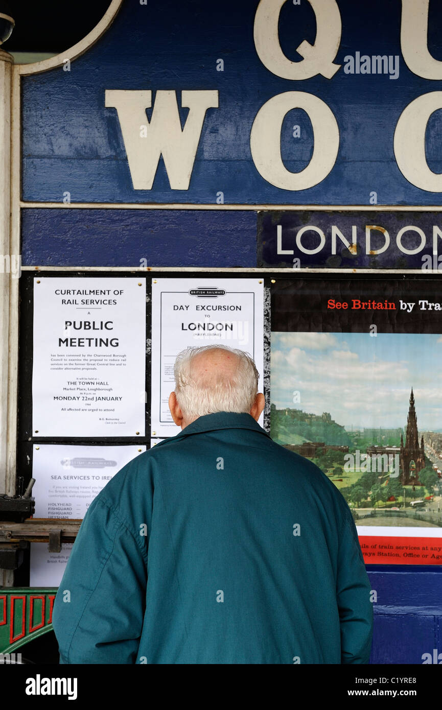 alte im Alter Rentner Blick auf Bahn Fahrplan Quorn und Woodhouse Bahnhof Quorn und Woodhouse England uk Stockfoto