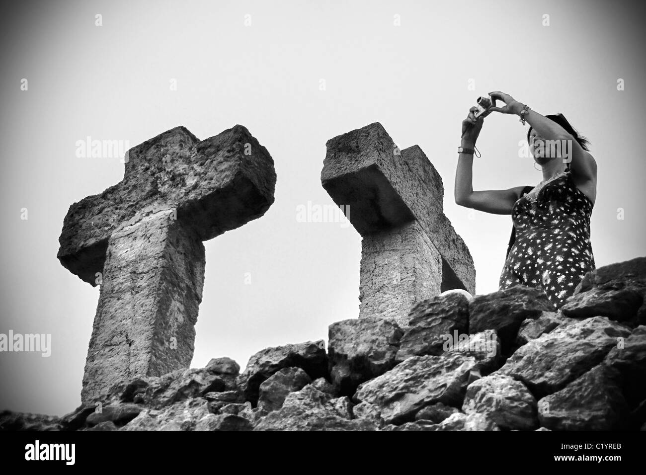 Eine Frau, die ein Bild an der Spitze der Tortur (Steinhügel), die höchste Stelle im Parc Güell, Barcelona, Spanien. Stockfoto