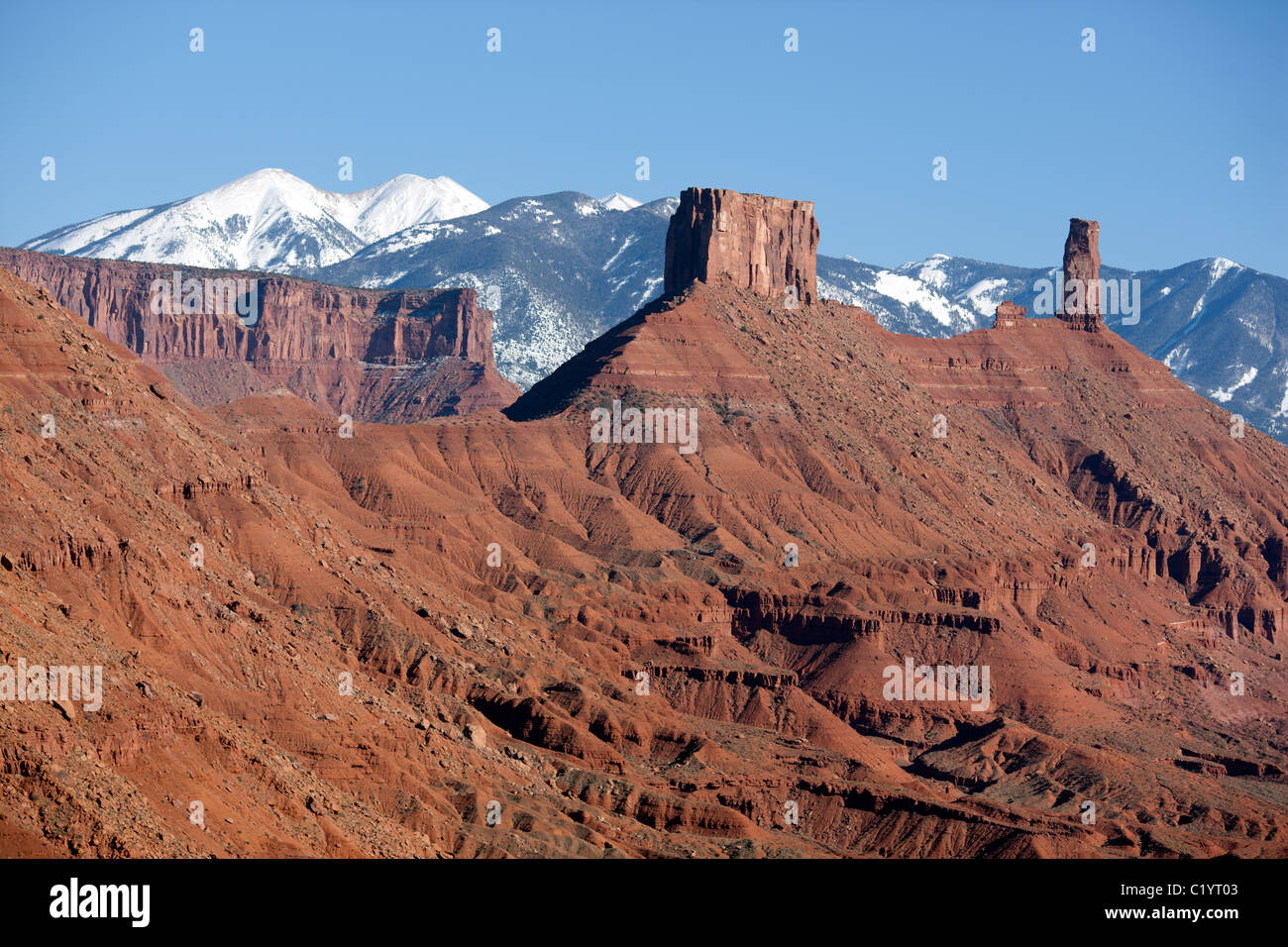 LUFTAUFNAHME. Monolithen aus rotem Sandstein im Castle Rock und schneebedeckten La Sal Mountains. Moab, Grand County, Utah, USA. Stockfoto
