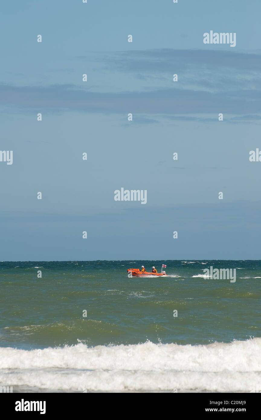 RNLI-Rettungsboot Beschleunigung entlang der Küste. Stockfoto