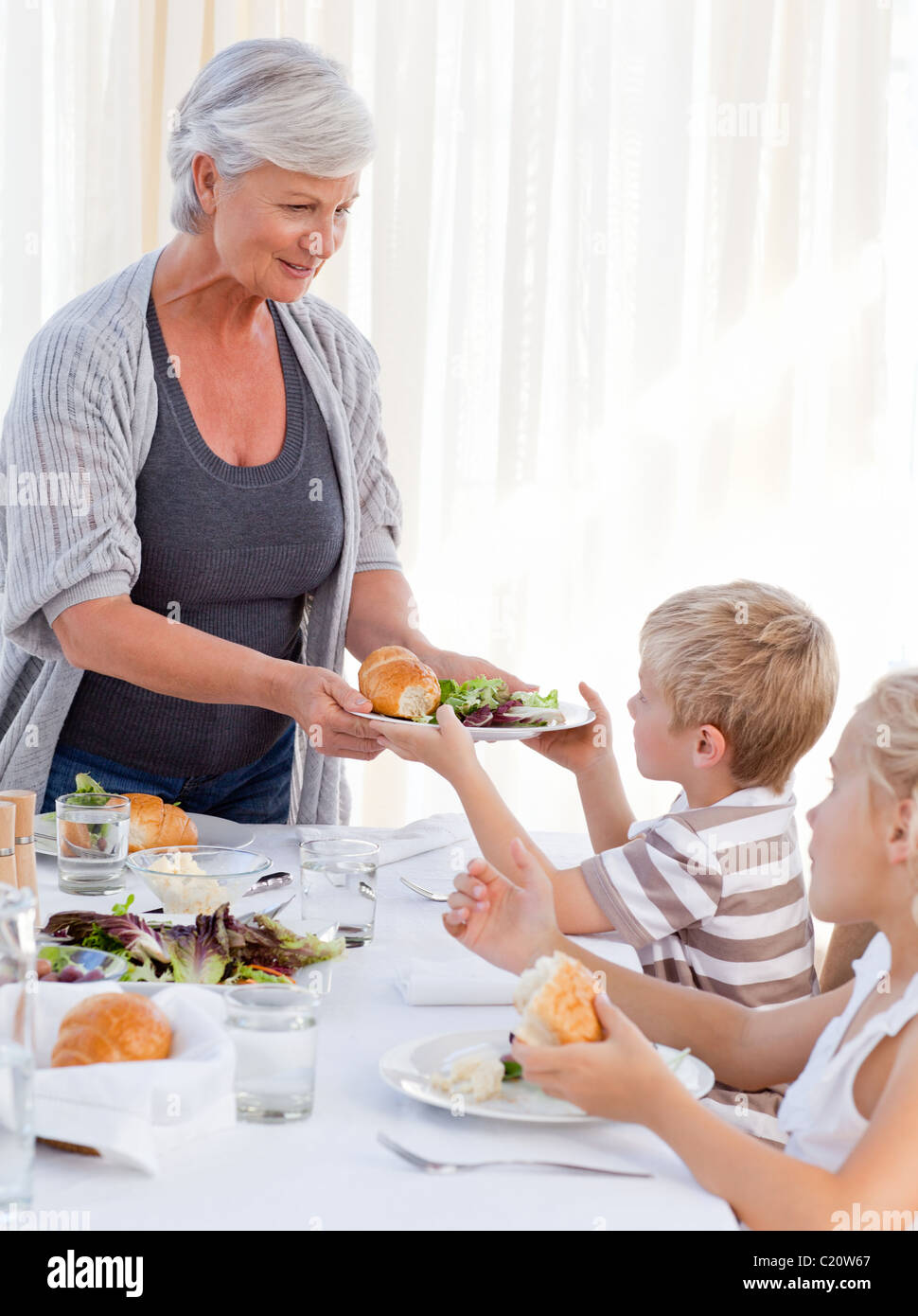 Großmutter ihren Enkel etwas zu essen zu geben, während des Essens Stockfoto