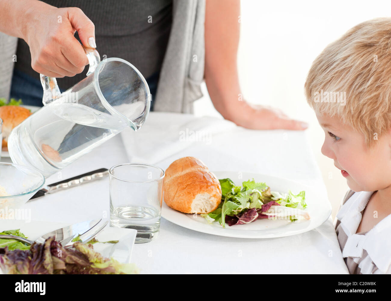 Großmutter ihren Enkel etwas Wasser zu geben, während des Essens Stockfoto