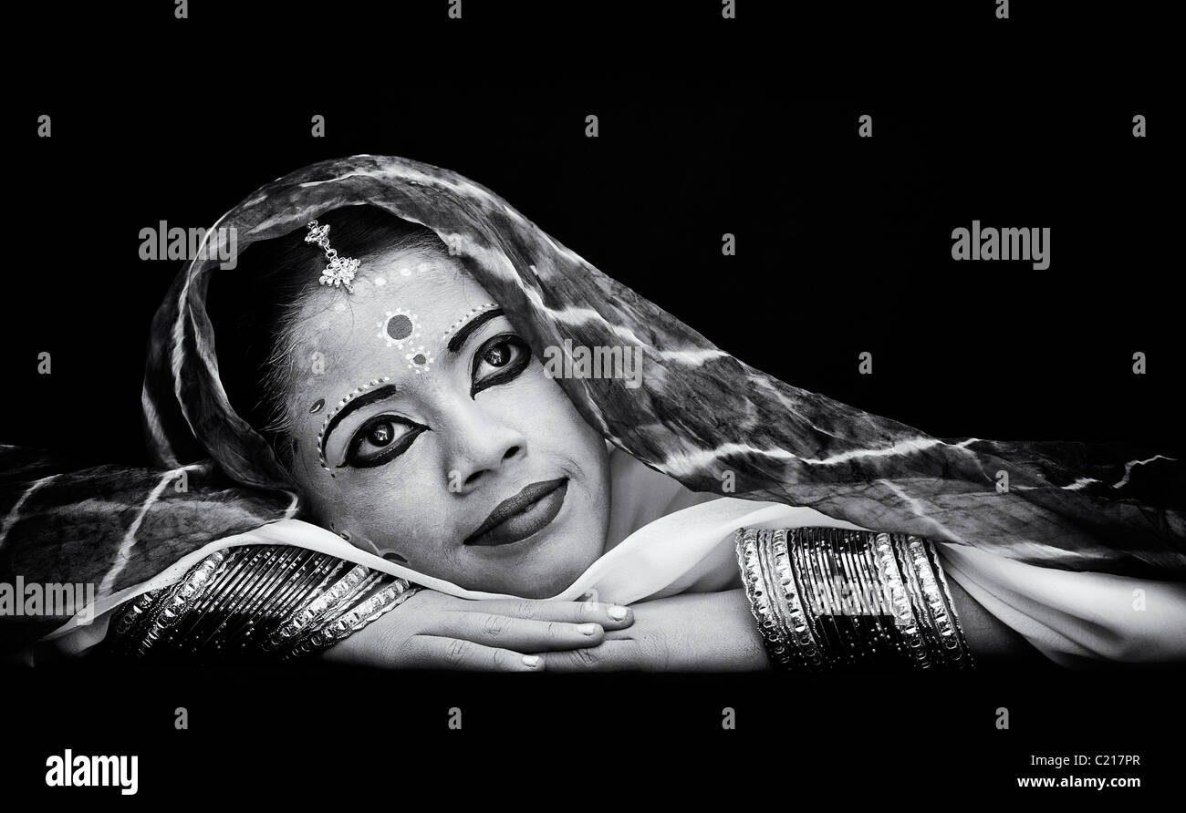 Indische Mädchen träumen. Gesicht gemalt als die Hindu-Göttin Sita vor einem schwarzen Hintergrund. Monochrom Stockfoto