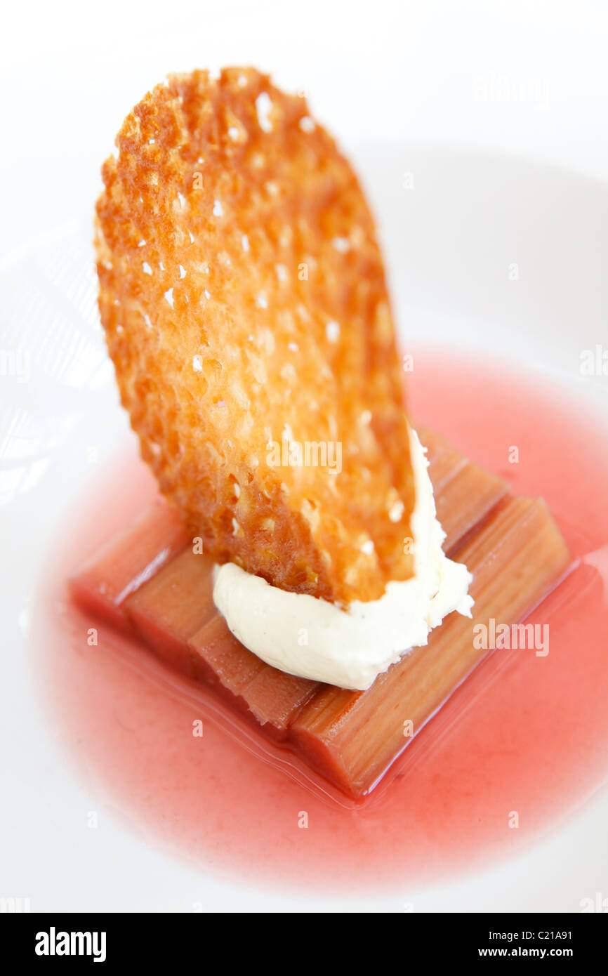 Dessert gewürzte Rhabarber mit Sahne und einen Brandy Snap-Keks. Stockfoto