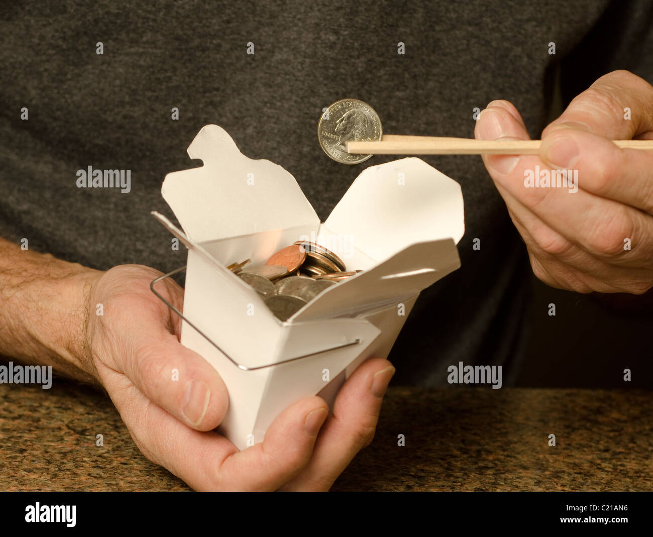 Mann, der chinesische Lebensmittel-Container mit US-Währung hält Stockfoto