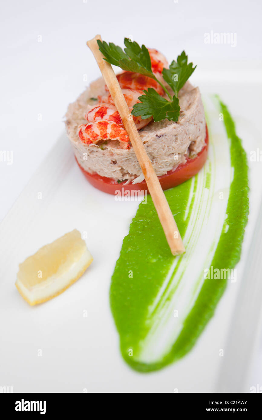 Vorspeise mit Fisch Pastete mit Flusskrebsschwänze, Zitronenscheibe und eine Suppenstange. Stockfoto