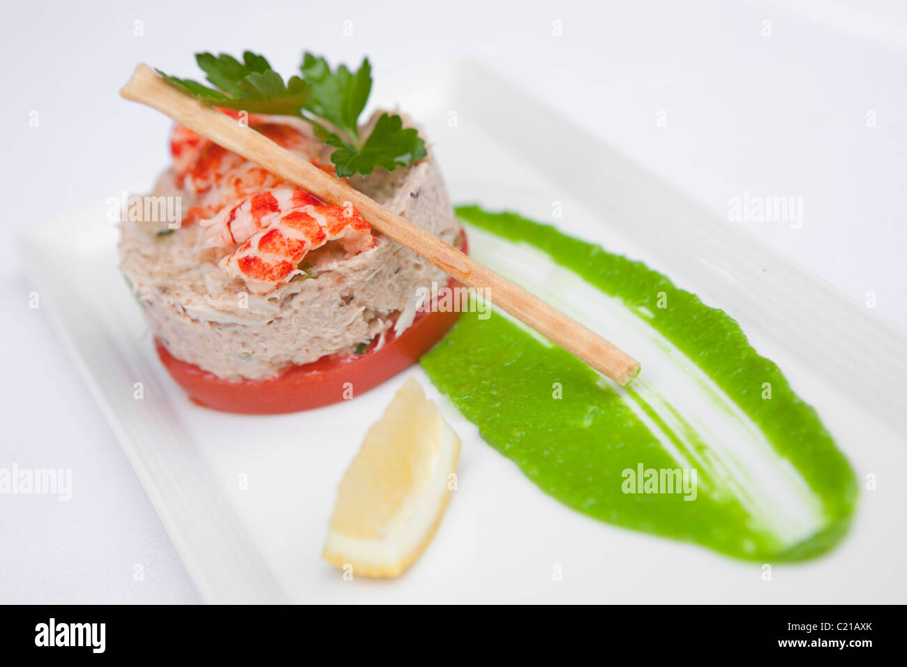 Vorspeise mit Fisch Pastete mit Flusskrebsschwänze, Zitronenscheibe und eine Suppenstange. Stockfoto