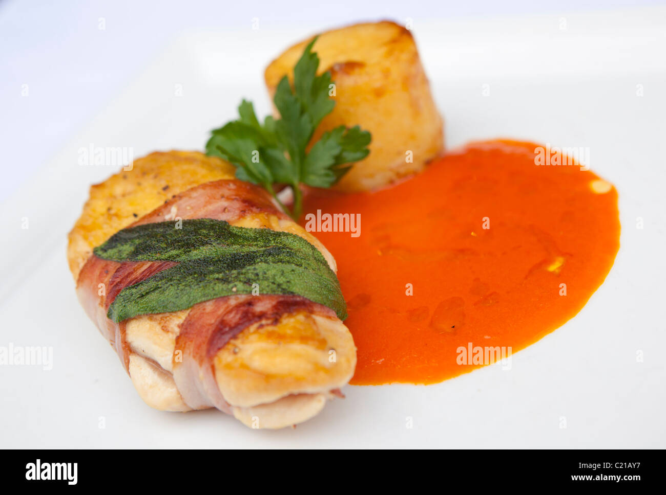 Die Hauptmahlzeit Huhn in Parma-Schinken mit Tomaten und Mascarpone Jus gewickelt. Stockfoto