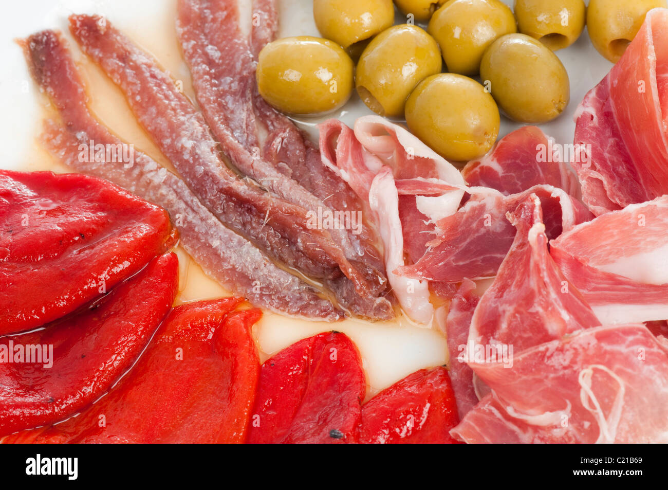 Spanische Tapas mit Serrano-Schinken gebraten, Piquillo Paprika, Oliven, Sardellen und Salat. Stockfoto