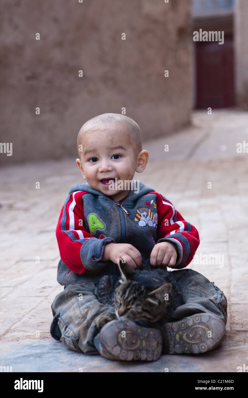 Xinjiang: uigurische Kind mit Katze Stockfoto