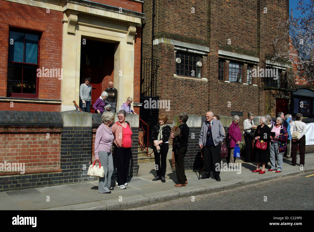 Eine Gruppe von U3A-Mitgliedern wartet auf einen Bus vor Leighton House, London, Großbritannien Stockfoto