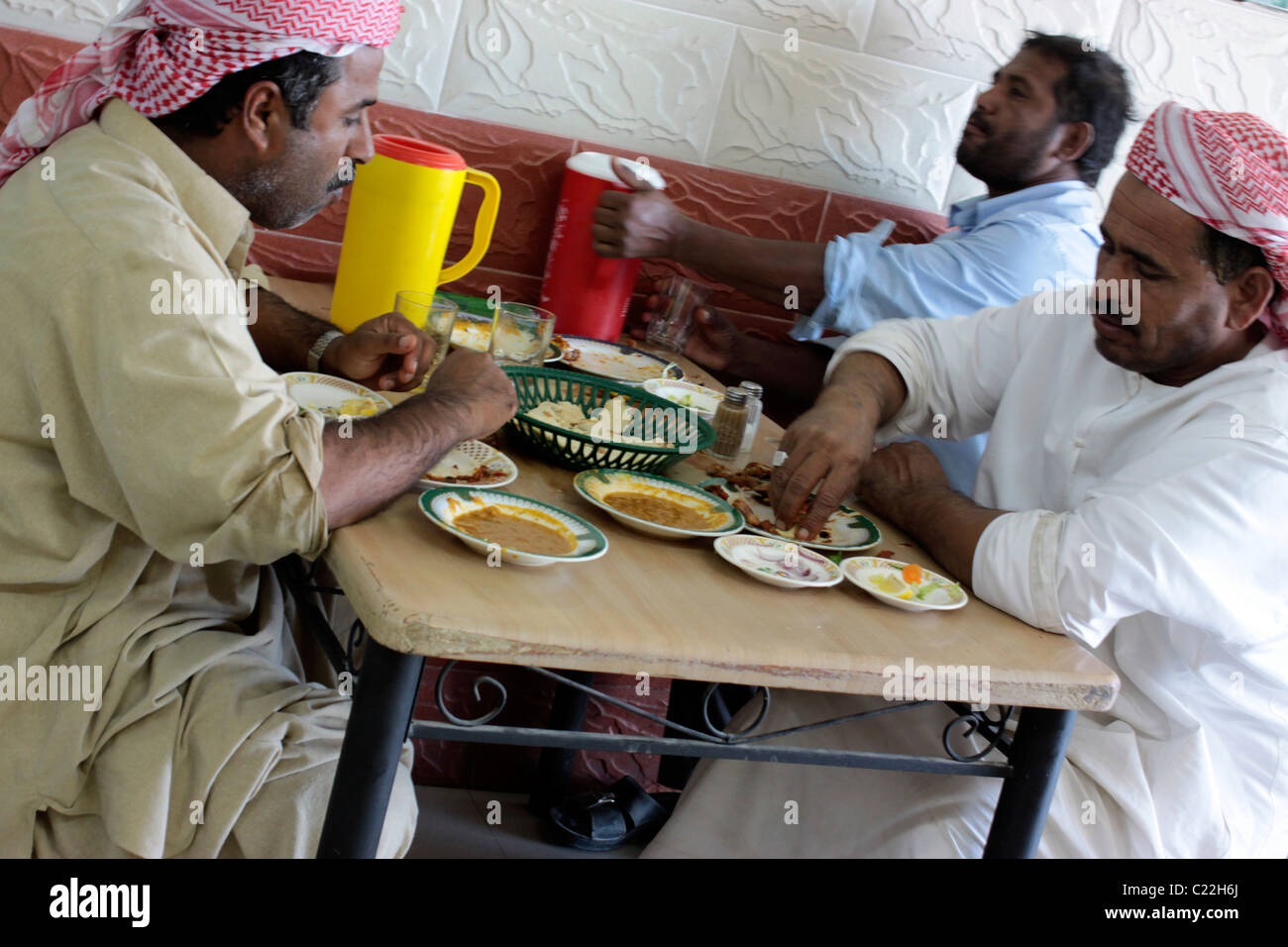 Eine Gruppe von Männern Essen in einem Straßencafé in Abu Dhabi, Vereinigte Arabische Emirate Stockfoto