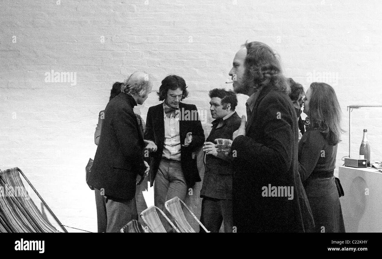 Charles Jencks in Bow Tie im Gespräch mit schottischen Künstlers Edouardo Paolozzi mit Architekten Ron Herron von Archigram stehen im Vordergrund Peter Cook's Kunst Netz 1970 s Gallery in London UK 1974 KATHY DEWITT Stockfoto