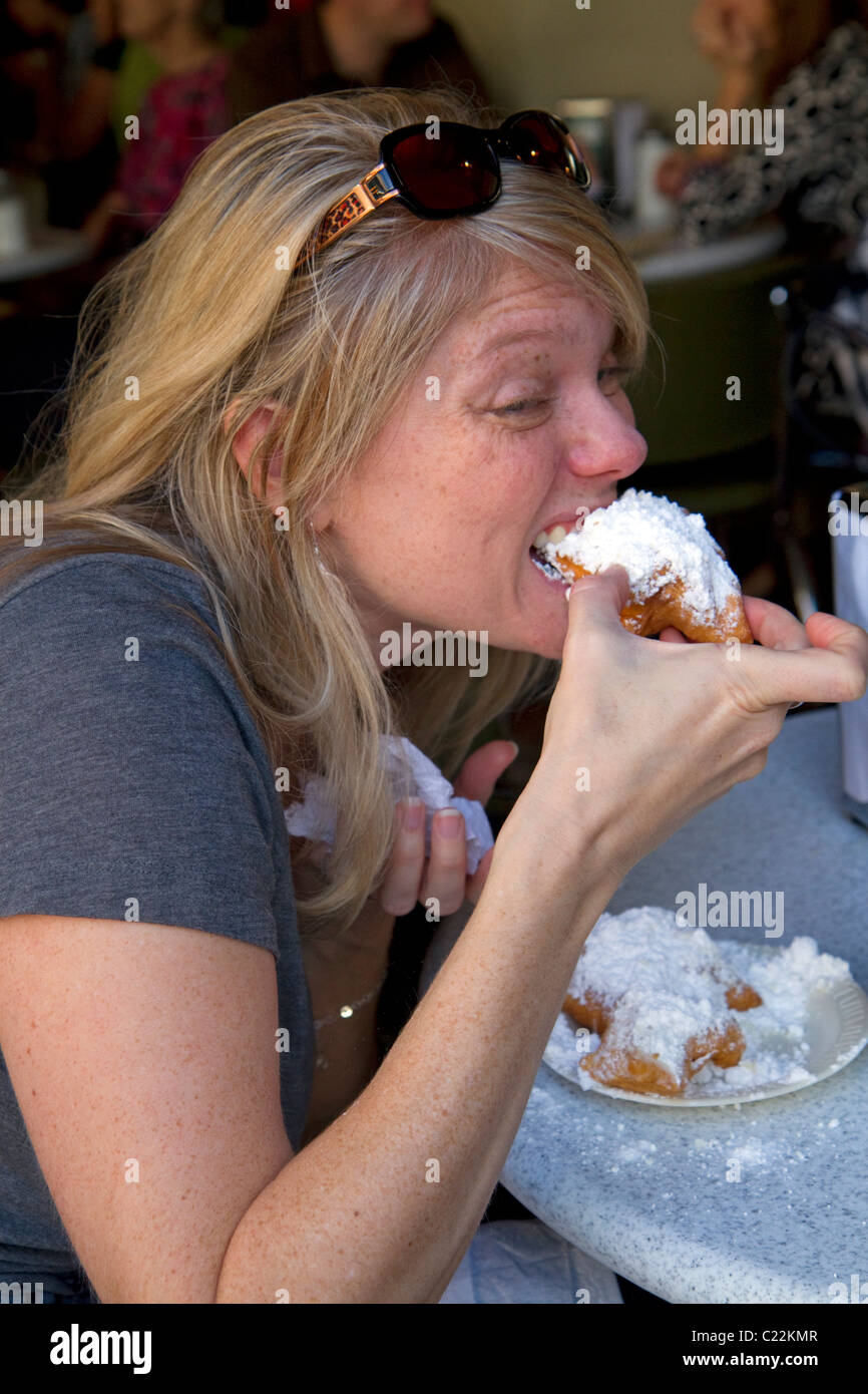 Frau Essen ein Beignet im Cafe Du Monde in der Französisch Quarter von New Orleans, Louisiana, USA. Stockfoto