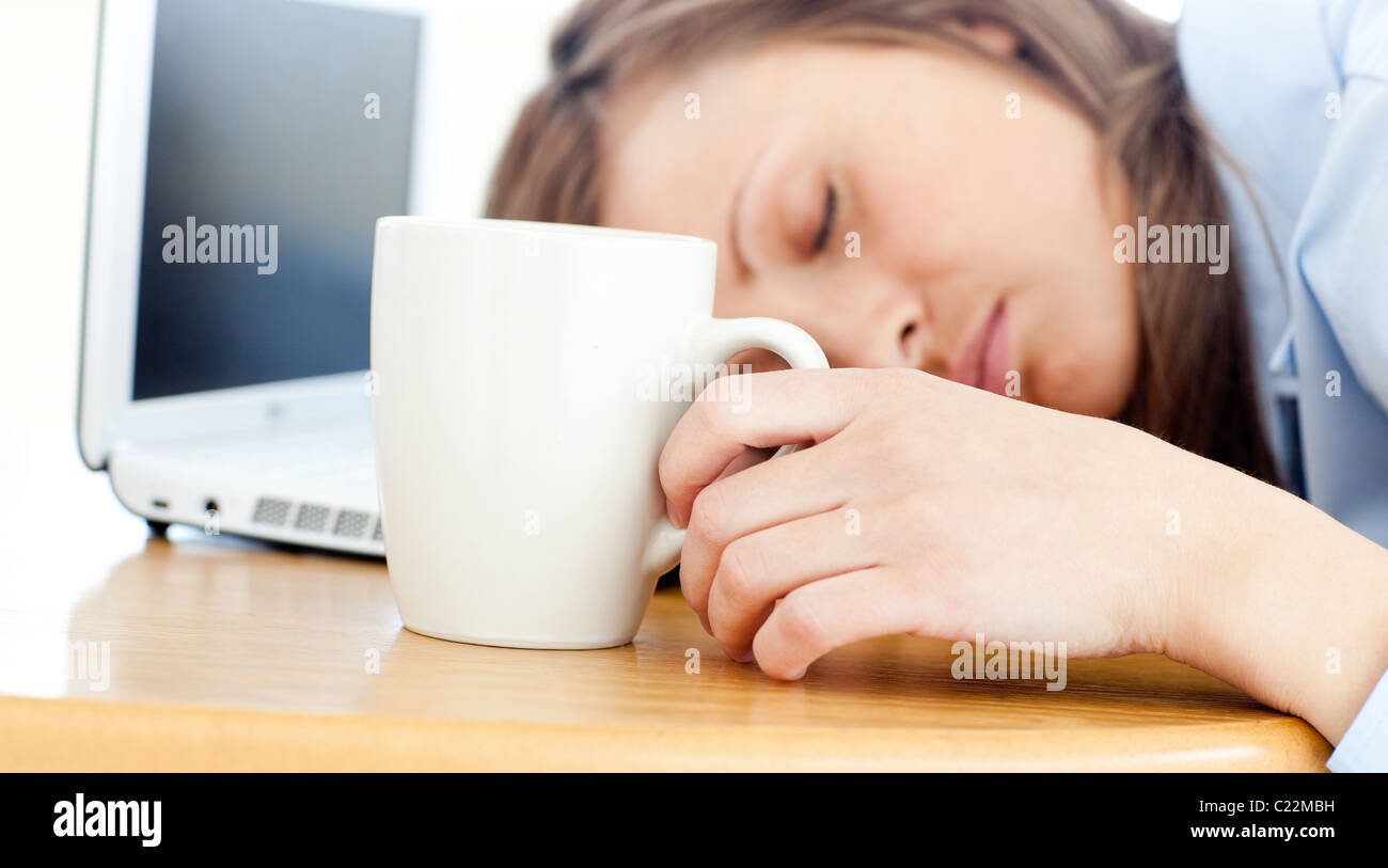 Slumbery Frau schläft auf Tisch im Büro Stockfoto
