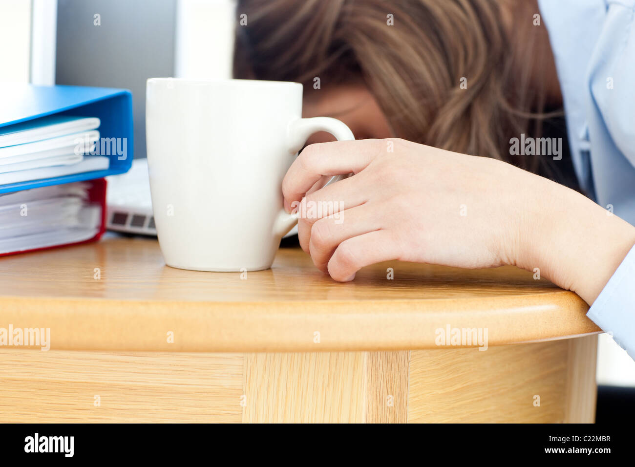 Verschlafenen Frau schläft auf Tisch im Büro Stockfoto