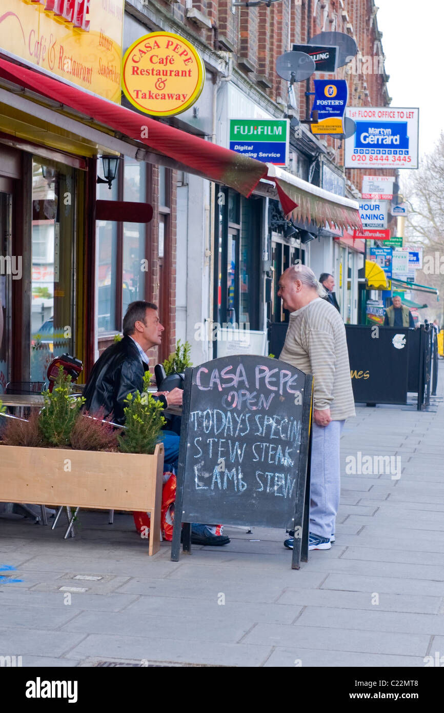 East Finchley, zwei applying ältere Männer mit grauen Haare im Pferdeschwanz Chat außerhalb der Casa Pepe Cafe oder Restaurant Stockfoto