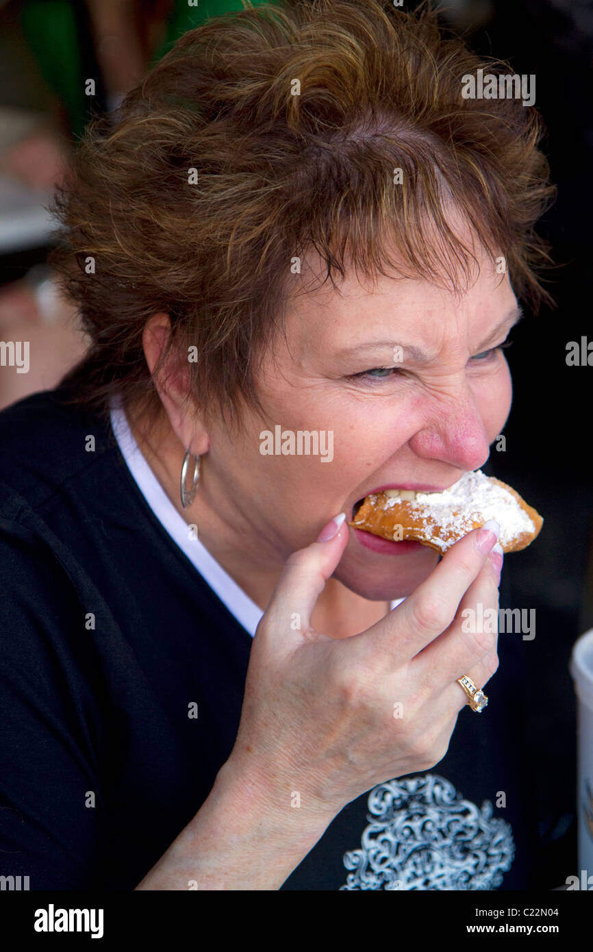 Frau Essen ein Beignet im Cafe Du Monde in der Französisch Quarter von New Orleans, Louisiana, USA. Stockfoto